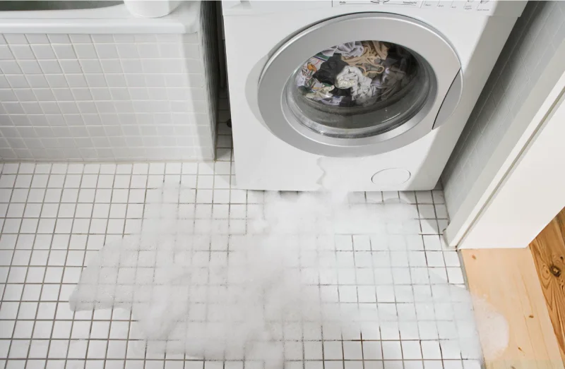 washing machine leaking with visible foam on the ground